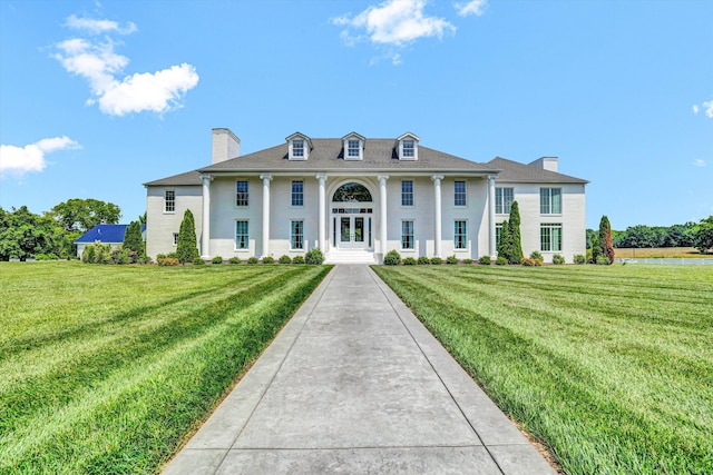 189 Old Buckingham Rd, Cumberland, VA 23040 - neoclassical home featuring a chimney, a front lawn, and stucco siding