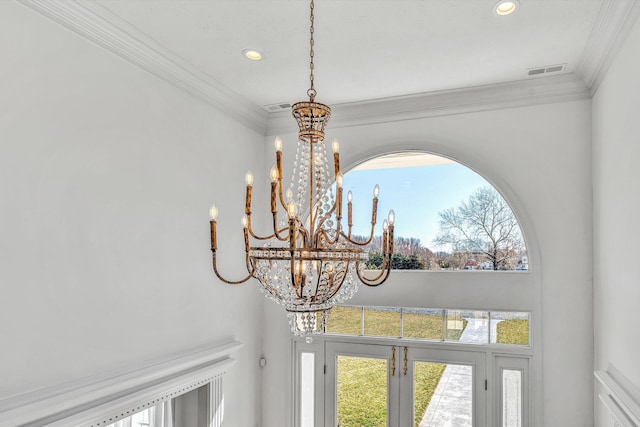 interior details with visible vents, ornamental molding, and a notable chandelier