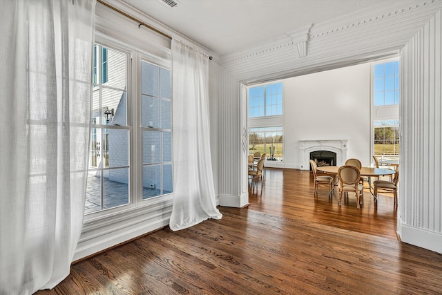 dining space featuring a premium fireplace, wood finished floors, and a wealth of natural light