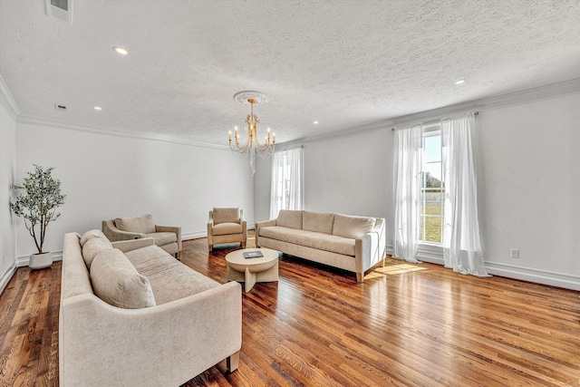 living area featuring a textured ceiling, a wealth of natural light, a chandelier, and ornamental molding