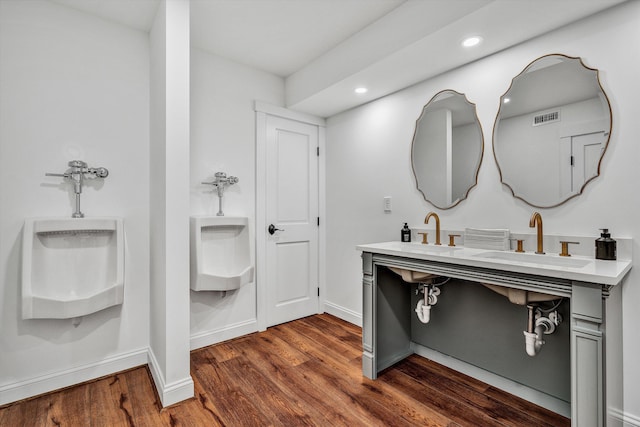 bathroom with wood finished floors, a sink, visible vents, and recessed lighting