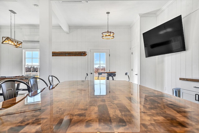 unfurnished dining area featuring a chandelier, a healthy amount of sunlight, and beam ceiling
