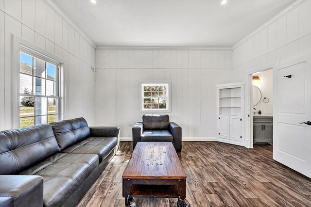 living room featuring baseboards, dark wood-type flooring, and ornamental molding
