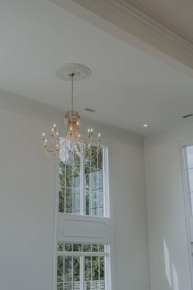 details featuring visible vents, a chandelier, and ornamental molding