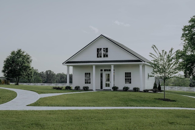view of front of property with fence, a porch, and a front lawn