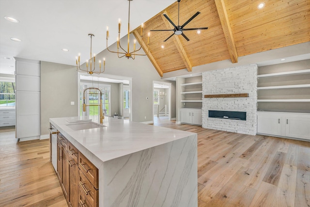 kitchen with light wood-type flooring, baseboards, a sink, and brown cabinets