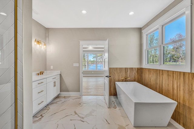 full bath featuring recessed lighting, a soaking tub, marble finish floor, and vanity