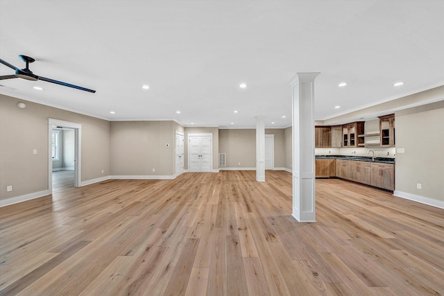 unfurnished living room featuring recessed lighting, light wood-style floors, a ceiling fan, and decorative columns