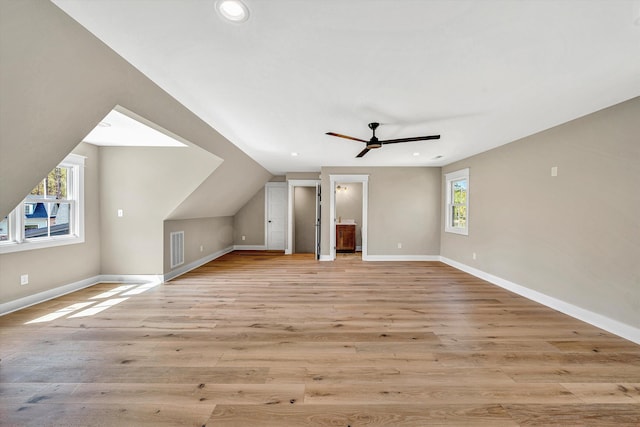 bonus room with light wood-style flooring, visible vents, and baseboards