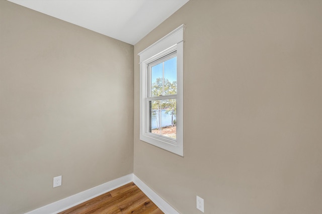 unfurnished room with light wood-type flooring and baseboards