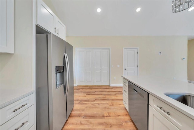 kitchen with appliances with stainless steel finishes, light wood-style floors, white cabinetry, and light countertops