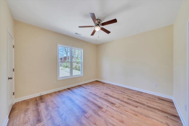 spare room featuring ceiling fan, baseboards, wood finished floors, and visible vents