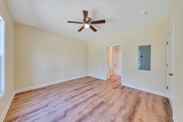 unfurnished room featuring light wood-type flooring, electric panel, baseboards, and ceiling fan