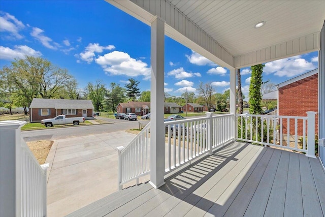 wooden deck featuring a residential view and covered porch