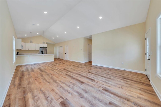 unfurnished living room with lofted ceiling, baseboards, light wood finished floors, and recessed lighting
