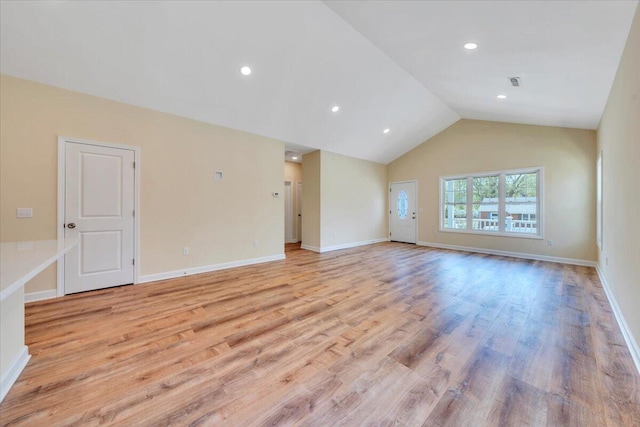 spare room with light wood-style floors, lofted ceiling, visible vents, and baseboards