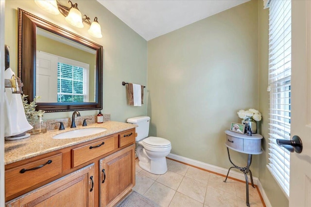 bathroom featuring baseboards, tile patterned flooring, vanity, and toilet