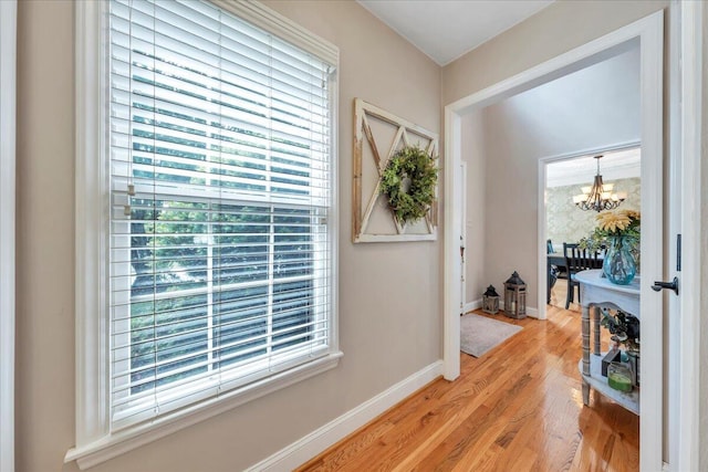 interior space with plenty of natural light, light wood-style flooring, and a notable chandelier