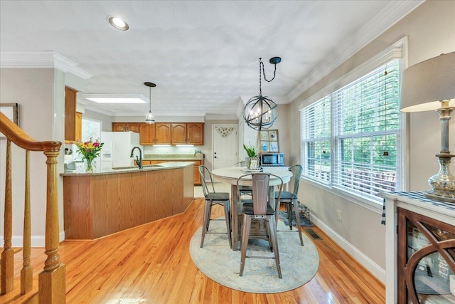dining space featuring crown molding, light wood finished floors, recessed lighting, baseboards, and visible vents
