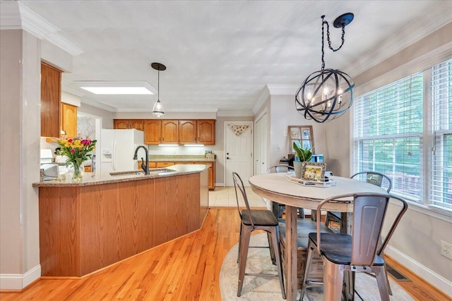 dining room featuring baseboards, a notable chandelier, ornamental molding, and light wood-style floors