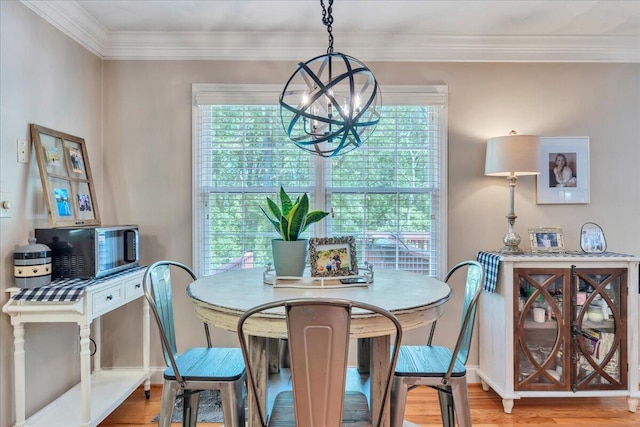 dining area with baseboards, a chandelier, ornamental molding, and wood finished floors