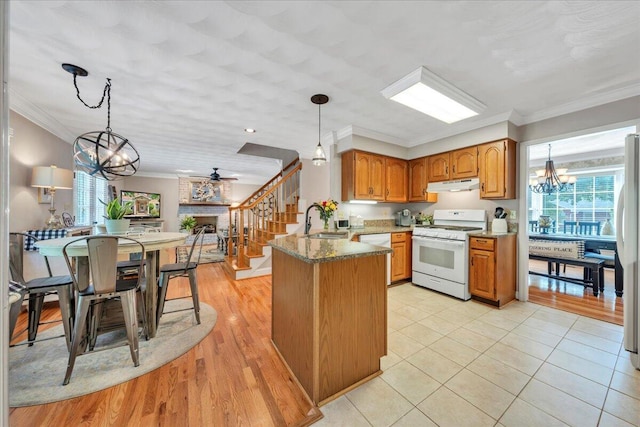 kitchen featuring an inviting chandelier, plenty of natural light, white appliances, and a sink