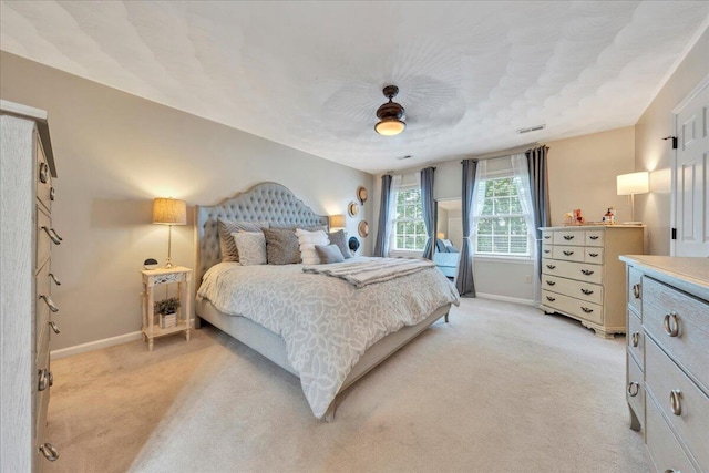 bedroom with baseboards, ceiling fan, light carpet, and visible vents