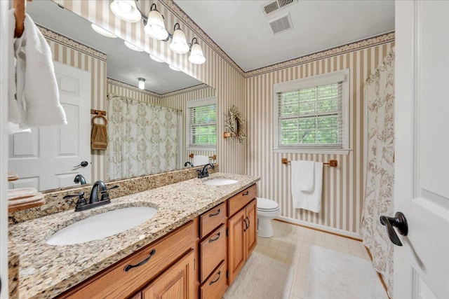 bathroom featuring a sink and wallpapered walls