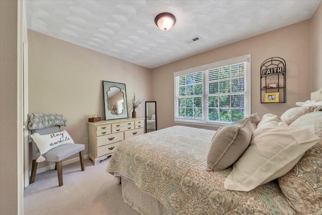 bedroom with light colored carpet, baseboards, and visible vents