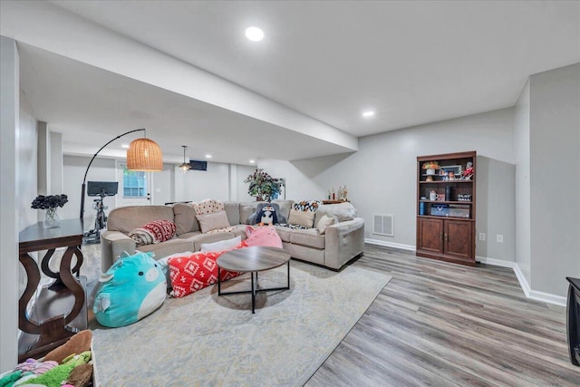 living area featuring light wood-style floors, recessed lighting, baseboards, and visible vents