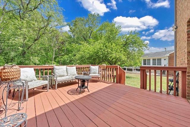wooden deck with an outdoor living space and a yard