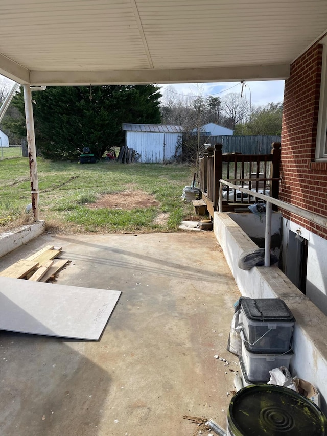 view of patio / terrace featuring a storage unit and an outbuilding