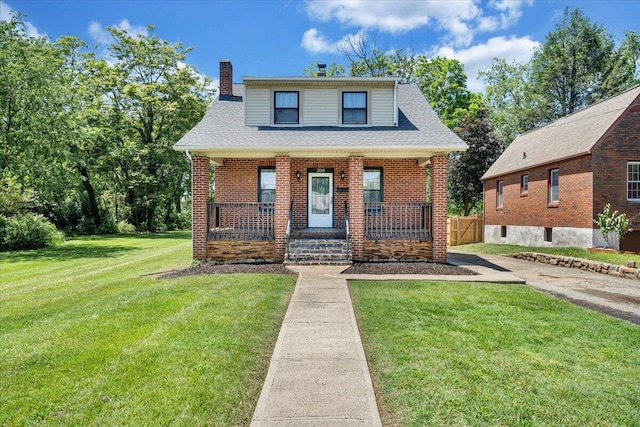 bungalow featuring a porch, a chimney, and brick siding