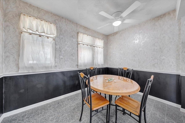 dining space featuring baseboards, ceiling fan, wallpapered walls, and tile patterned floors