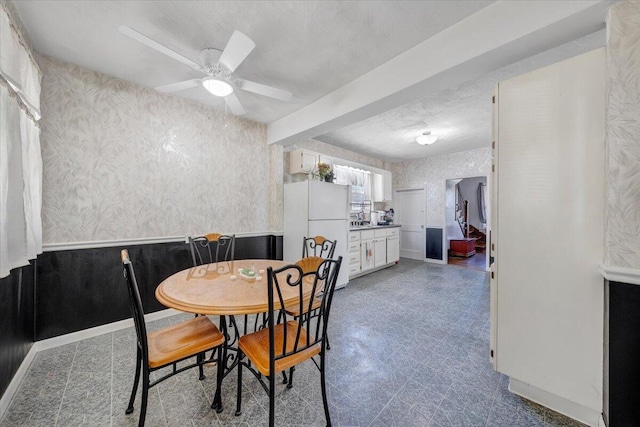 dining room featuring tile patterned floors, wallpapered walls, and ceiling fan