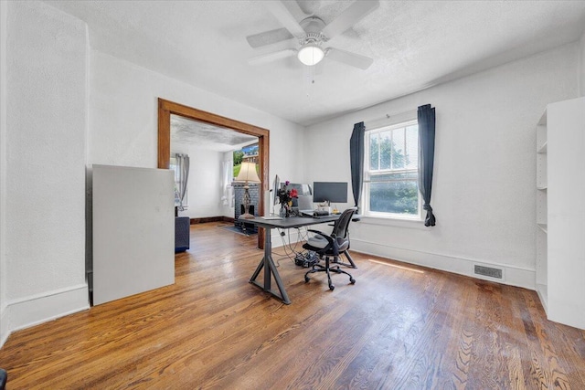 home office featuring wood finished floors, ceiling fan, and baseboards