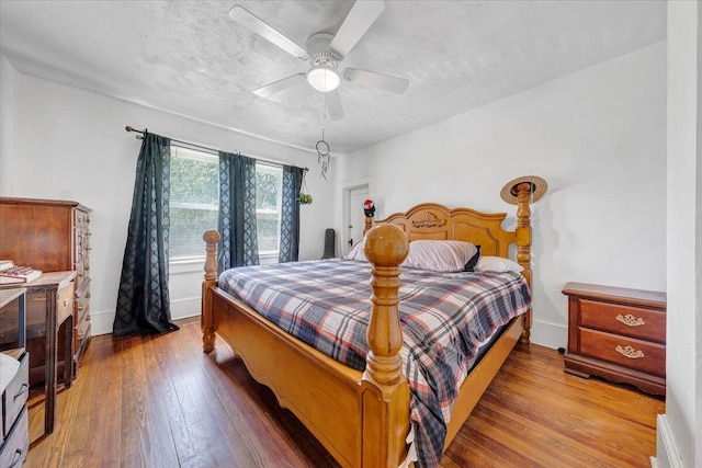 bedroom featuring wood-type flooring, baseboards, and ceiling fan