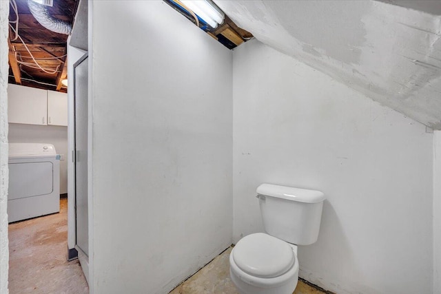 bathroom with washer / clothes dryer, unfinished concrete flooring, and toilet