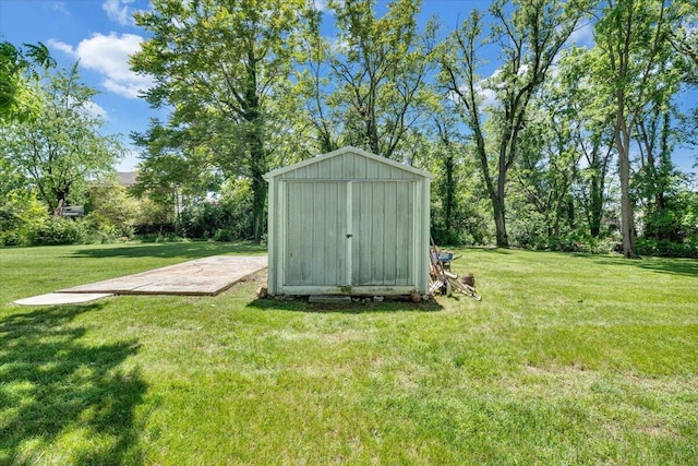 view of grassy yard featuring a storage unit and an outbuilding