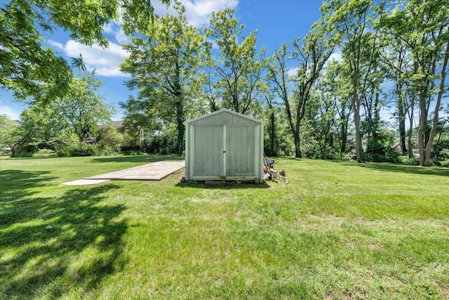 view of grassy yard featuring a storage shed and an outdoor structure