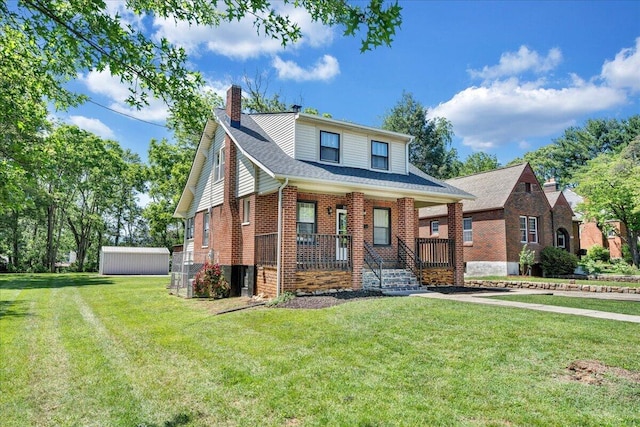 view of front of home with covered porch, a chimney, a front lawn, brick siding, and a shingled roof