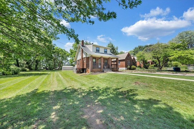 view of front of property featuring brick siding, a front yard, a chimney, and a porch