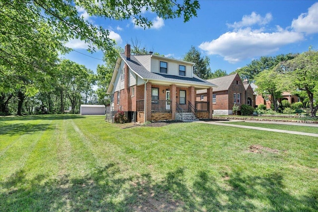 view of front facade with covered porch, brick siding, a chimney, and a front lawn