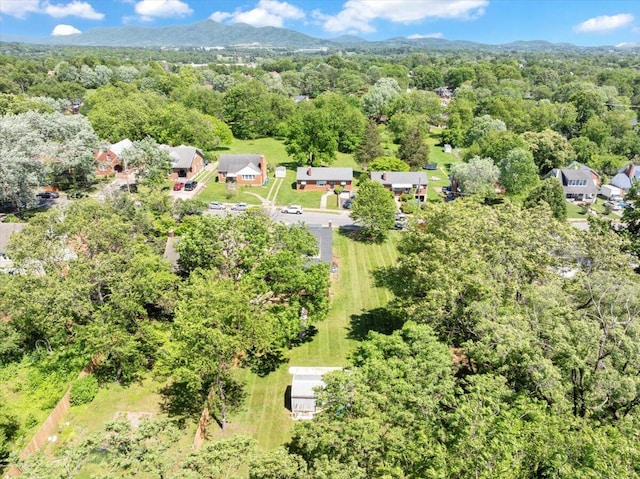 aerial view of property and surrounding area with a heavily wooded area and a mountainous background