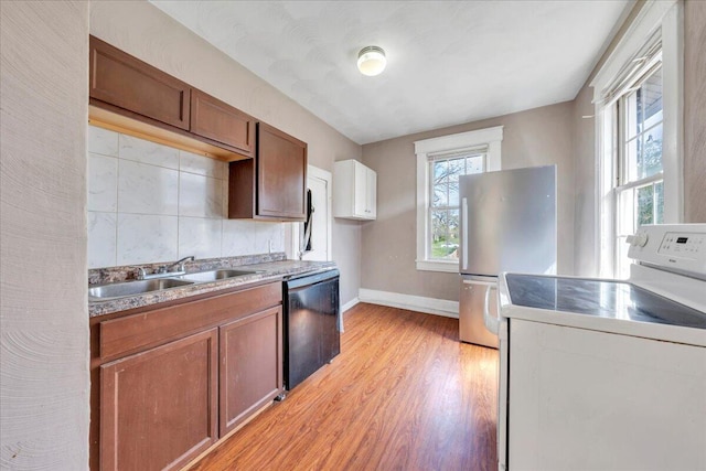 4 14th St SW, Roanoke, VA 24016 - kitchen with a sink, freestanding refrigerator, washer / dryer, black dishwasher, and light wood-style flooring