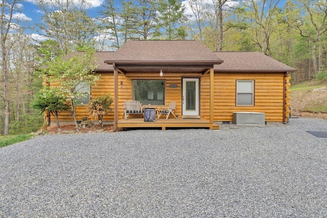 rear view of house with log exterior and roof with shingles