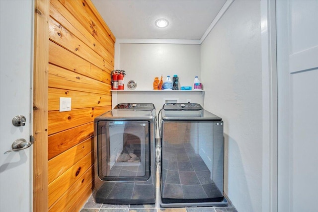 washroom featuring washing machine and clothes dryer, ornamental molding, and laundry area