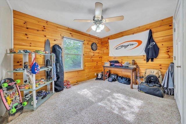 interior space featuring ceiling fan and wood walls