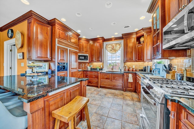 420 S Church St, Fincastle, VA 24090 - kitchen featuring built in appliances, a breakfast bar, decorative backsplash, stone tile flooring, and recessed lighting