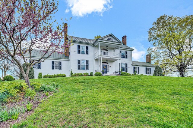420 S Church St, Fincastle, VA 24090 - view of front of property featuring a chimney, a balcony, ceiling fan, a front lawn, and metal roof